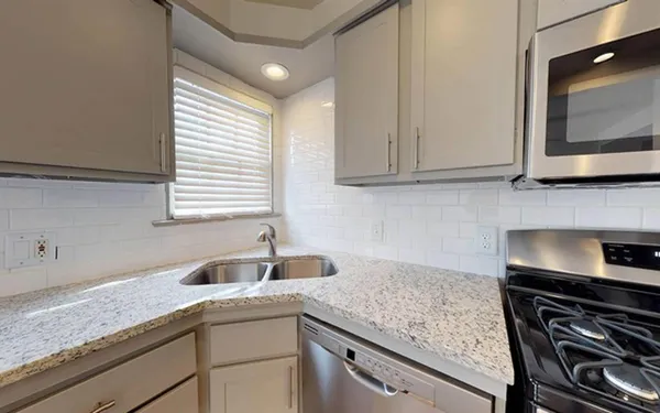 a kitchen with granite countertop a sink and a stove