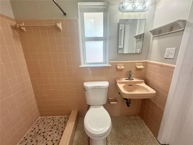 a bathroom with a sink a toilet and a mirror