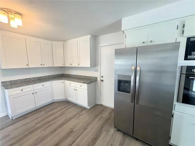a kitchen with stainless steel appliances cabinets a wooden floor and a sink