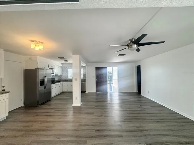 a view of a kitchen with a sink and refrigerator
