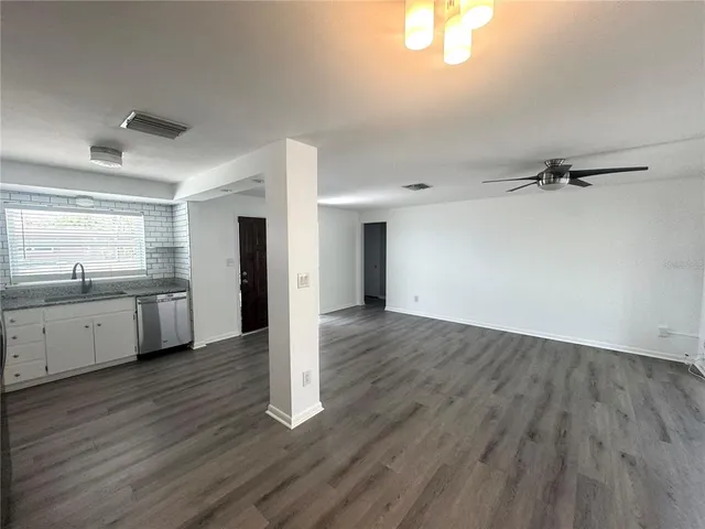 a view of a kitchen with wooden floor and a sink