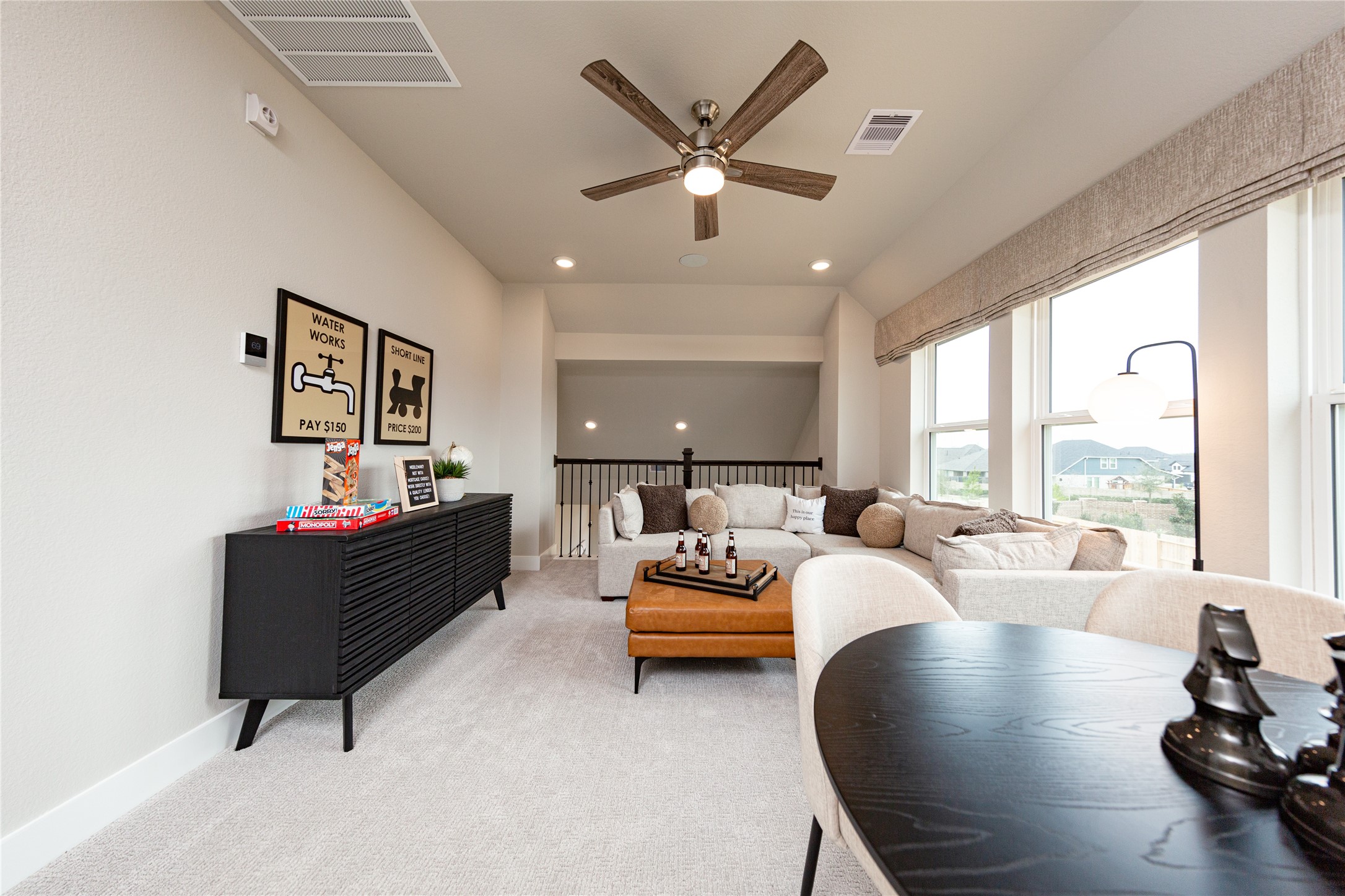 This open and airy upstairs game room offers a versatile added living space perfect for relaxation and entertainment. Large windows flood the area with natural light, while a modern ceiling fan keeps the space comfortable. This multi-functional loft serves as the ultimate bonus retreat for family and guests.