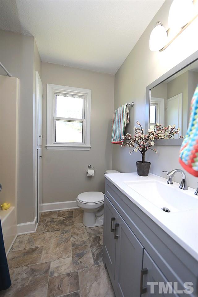 3312 High Gate Road Raleigh, NC 27603 - Photo 17 of 22 a bathroom with a sink a toilet and mirror