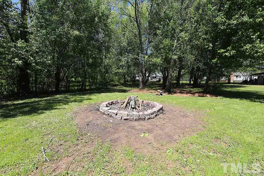 3312 High Gate Road Raleigh, NC 27603 - Photo 19 of 22 a view of a backyard with table and chairs and trees
