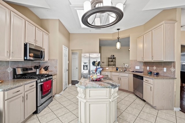 3103 Valley Court Manvel, TX 77578 - Photo 13 of 20 a kitchen with stainless steel appliances granite countertop a sink a stove a microwave and cabinets