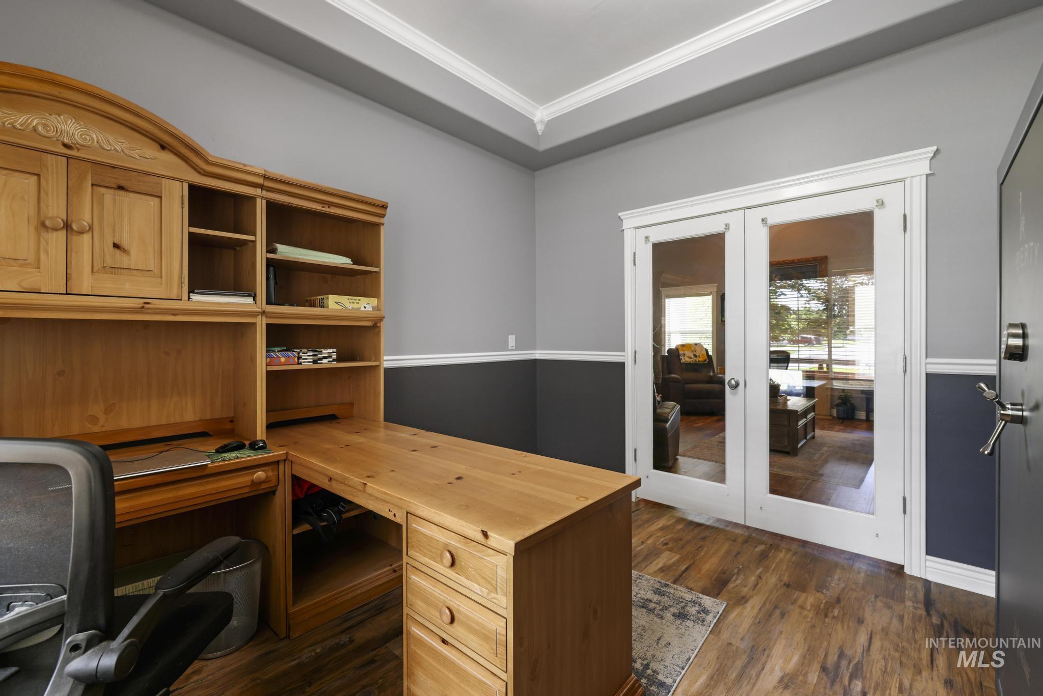 467 Wildrose Loop Twin Falls, ID 83301 - Photo 29 of 46 Room featuring wood-finish flooring, two-tone painted walls with chair rail molding, and white French doors