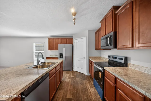 a kitchen with stainless steel appliances granite countertop a sink stove and refrigerator