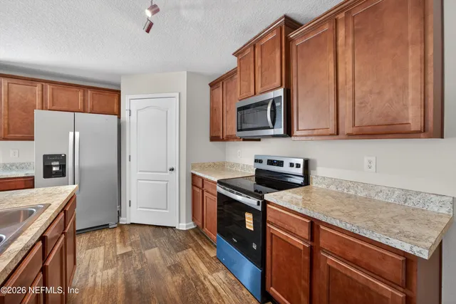 a kitchen with stainless steel appliances granite countertop a refrigerator microwave and sink