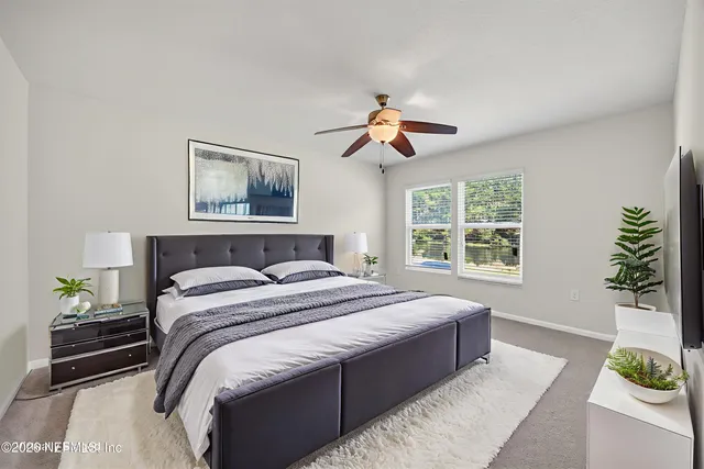 a bedroom with a large bed and a chandelier