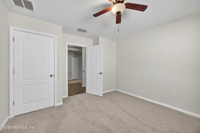 an empty room with a ceiling fan and a window