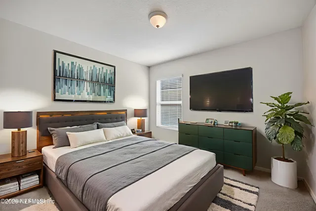 a bedroom with a bed and a flat screen tv