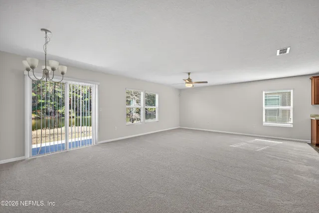 a view of a room with windows and ceiling fan