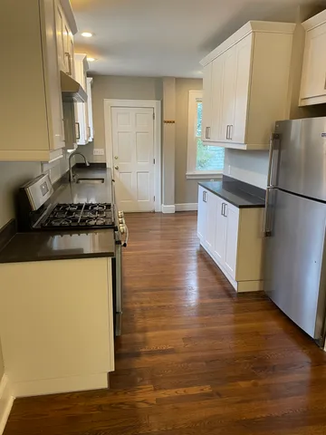 a kitchen with granite countertop a stove and a refrigerator