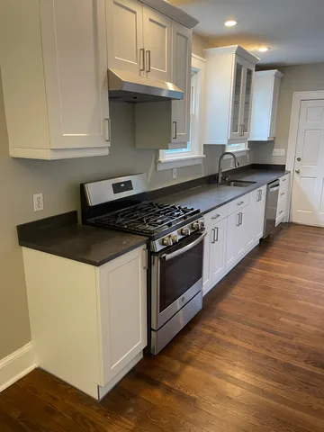 a kitchen with granite countertop a stove and cabinets