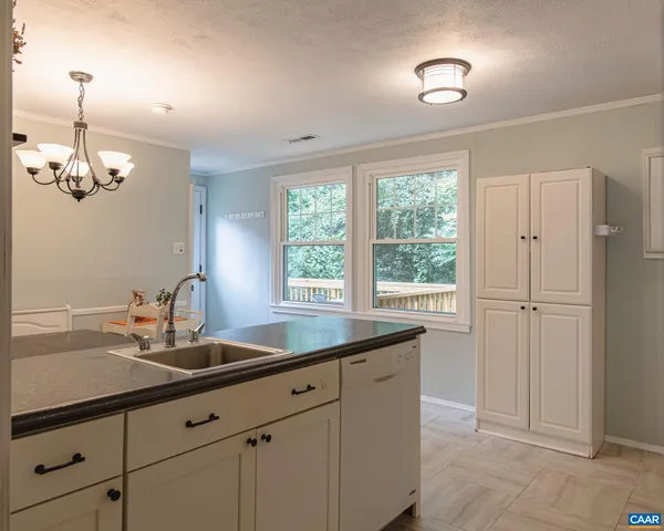 a bedroom with a bed and a large mirror next to a window