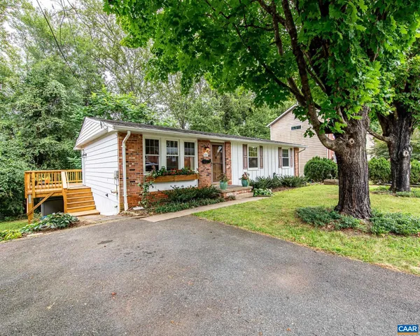 a view of a house with a yard and large tree