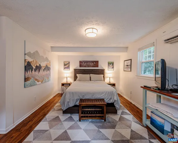 a bedroom with a bed and a flat screen tv