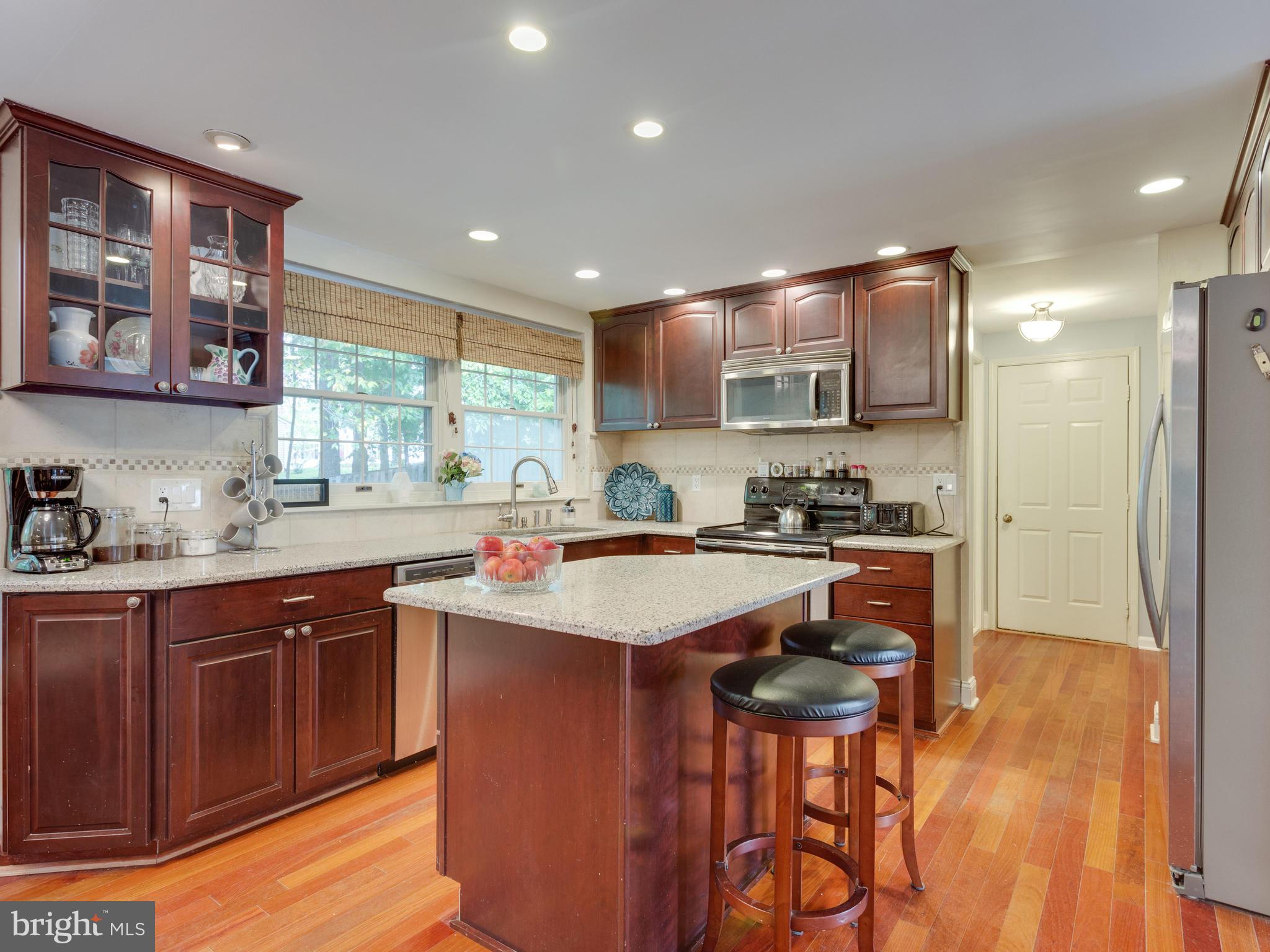 7817 Roundabout Way Springfield, VA 22153 - Photo 7 of 30 a kitchen with stainless steel appliances granite countertop a sink stove and refrigerator