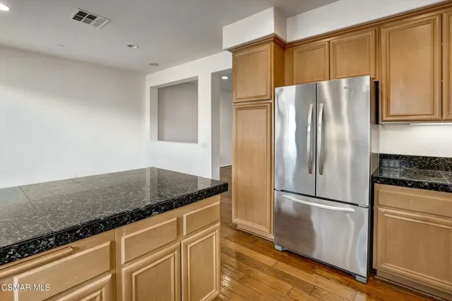 a kitchen with granite countertop a refrigerator stove and microwave