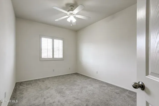 an empty room with chandelier fan
