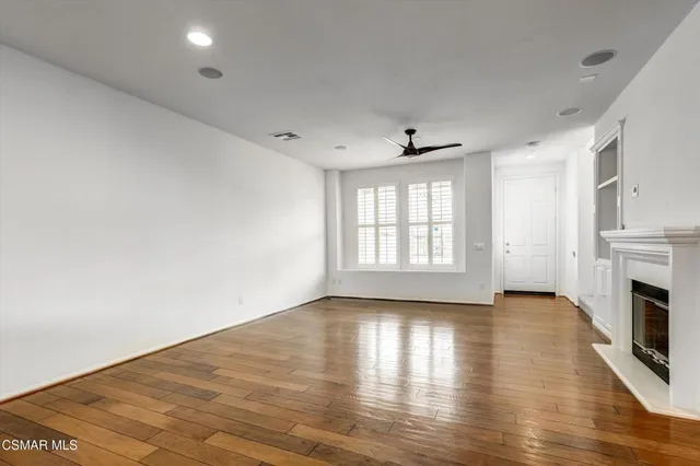 a kitchen with granite countertop wooden floors stainless steel appliances and a window