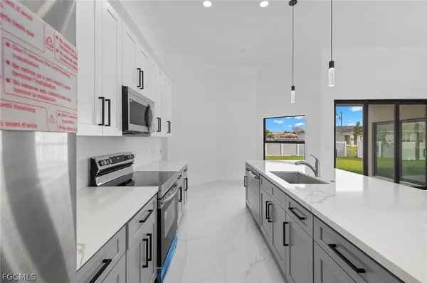 a kitchen with stainless steel appliances a sink a stove and a refrigerator