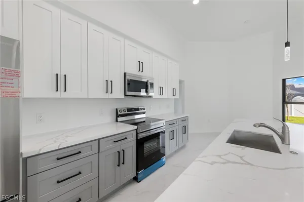 a kitchen with white cabinets stainless steel appliances and sink