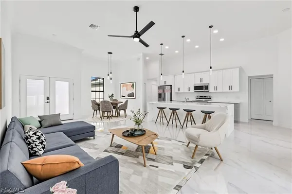 a living room with furniture kitchen view and a chandelier