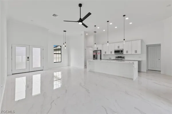 a large white kitchen with stainless steel appliances