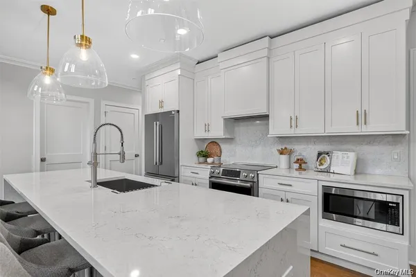 a kitchen with granite countertop white cabinets and white appliances
