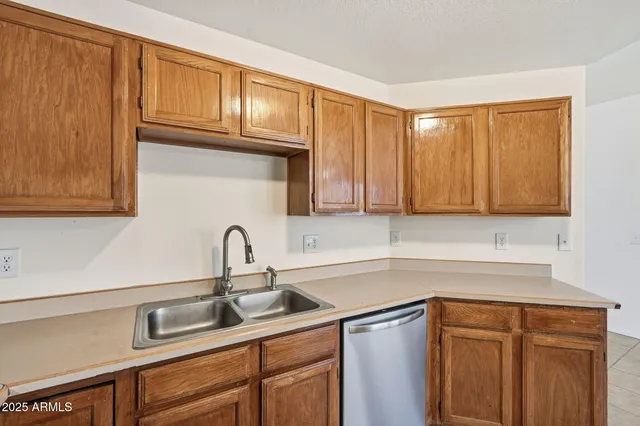 a kitchen with stainless steel appliances granite countertop a sink dishwasher cabinets and granite countertops with wooden floor