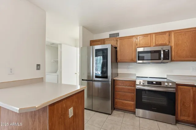 a kitchen with stainless steel appliances a stove microwave and refrigerator