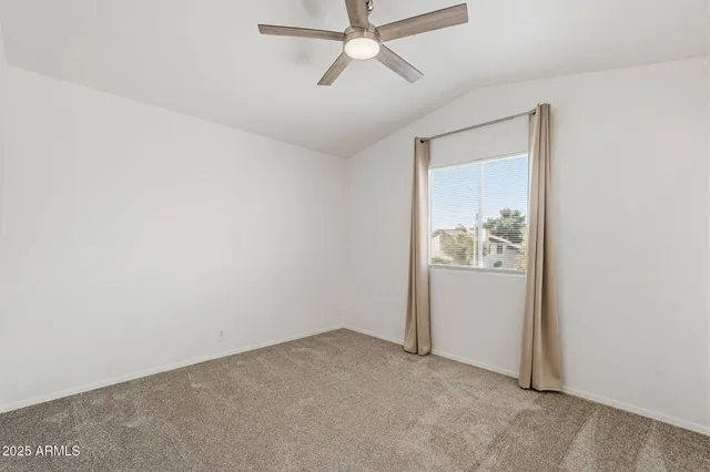 an empty room with chandelier fan