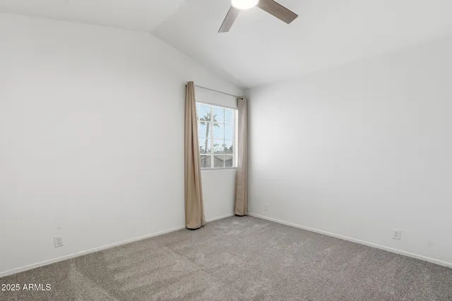 an empty room with a ceiling fan and a window