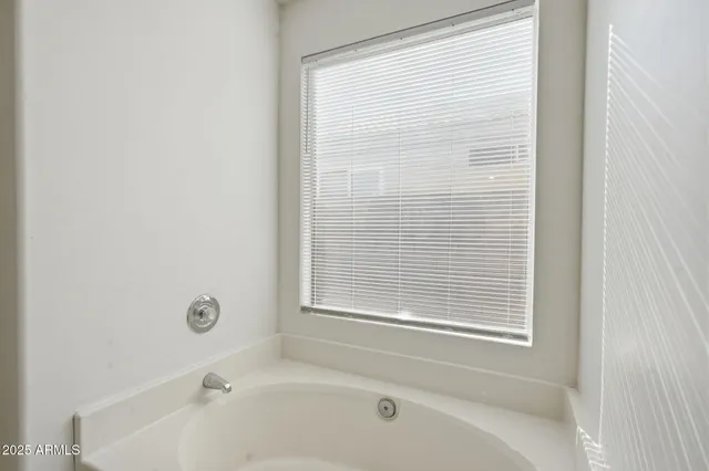 a bathroom with a bathtub next to a window
