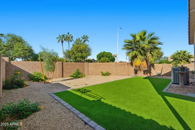 a view of yard with swimming pool and wooden fence