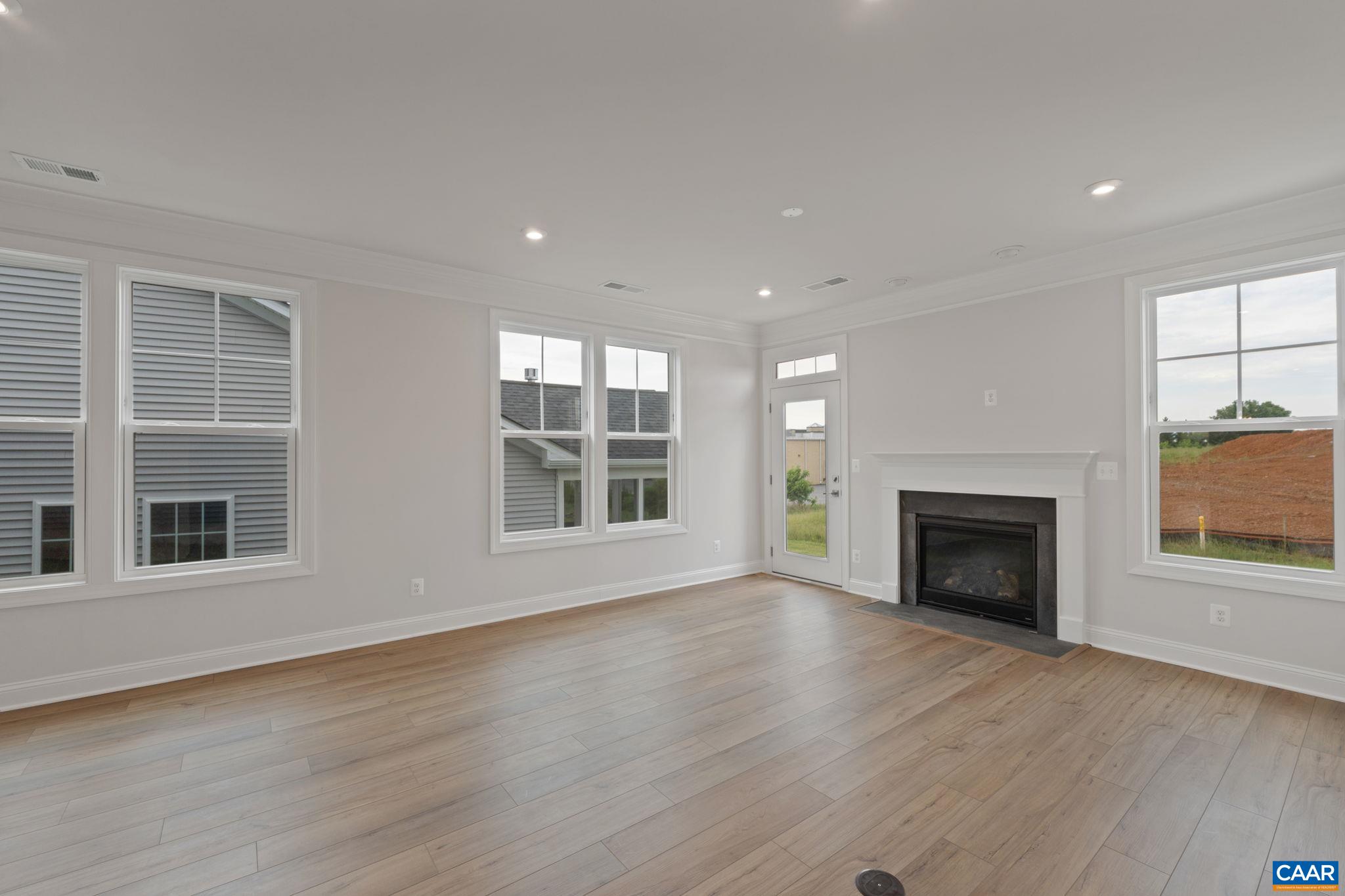 140 Springdale Road Waynesboro, VA 22980 - Photo 13 of 37 an empty room with wooden floor fireplace and windows