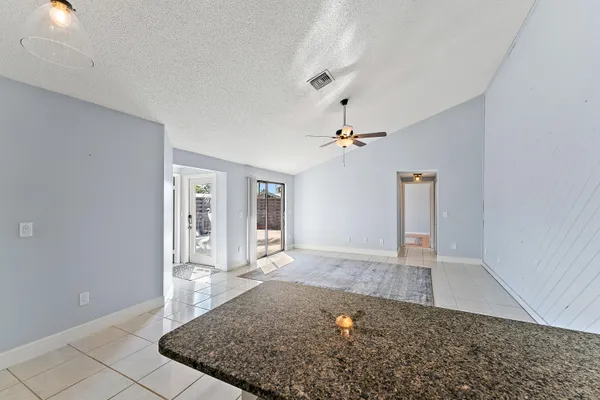 an empty room with windows and ceiling fan