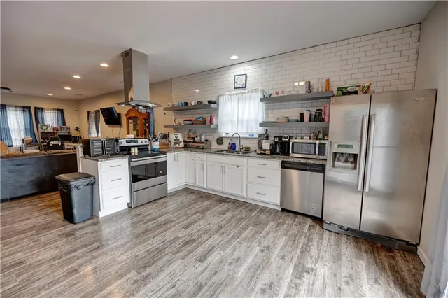 a kitchen with stainless steel appliances a refrigerator sink and microwave