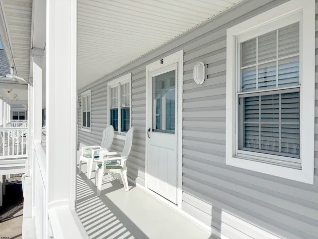 a view of a patio with table and chairs with wooden floor and fence