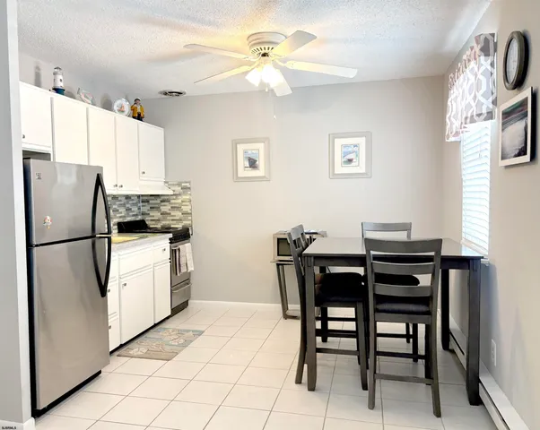 a kitchen with stainless steel appliances a white table and chairs in it