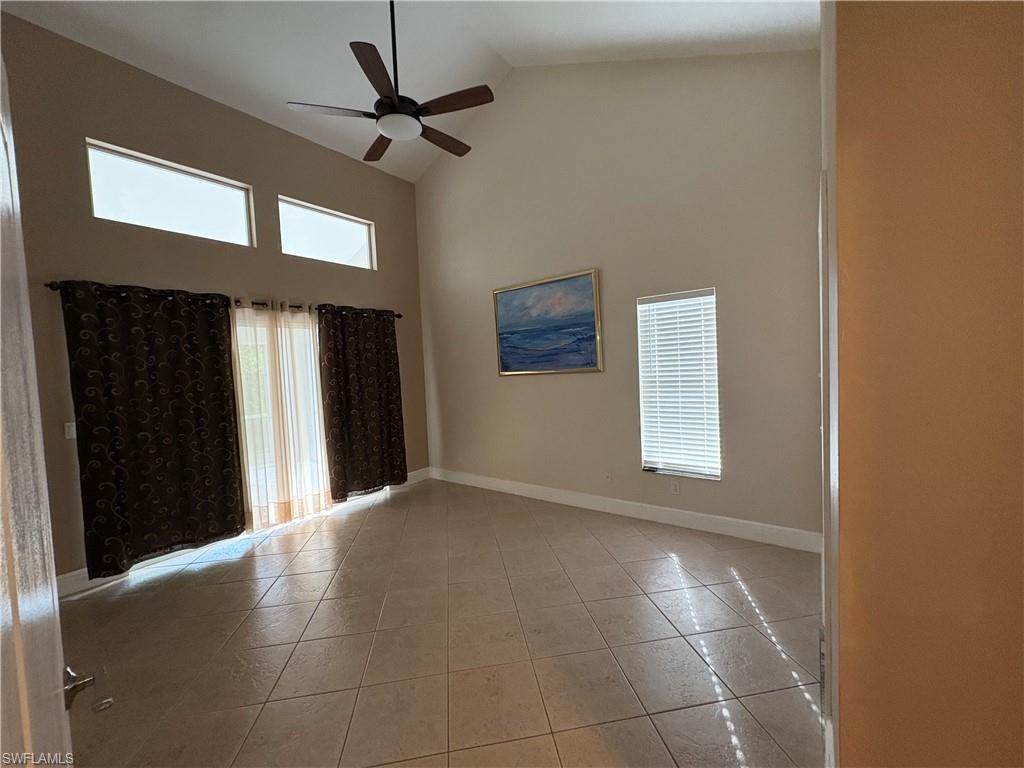 804 Bluebird Street Naples, FL 34104 - Photo 14 of 42 Unfurnished room with high vaulted ceiling, a ceiling fan, and light tile patterned flooring