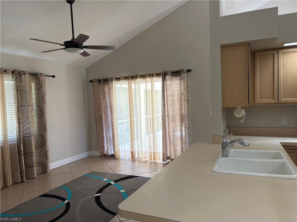 804 Bluebird Street Naples, FL 34104 - Photo 25 of 42 Kitchen with light countertops, lofted ceiling, light tile patterned floors, and a ceiling fan