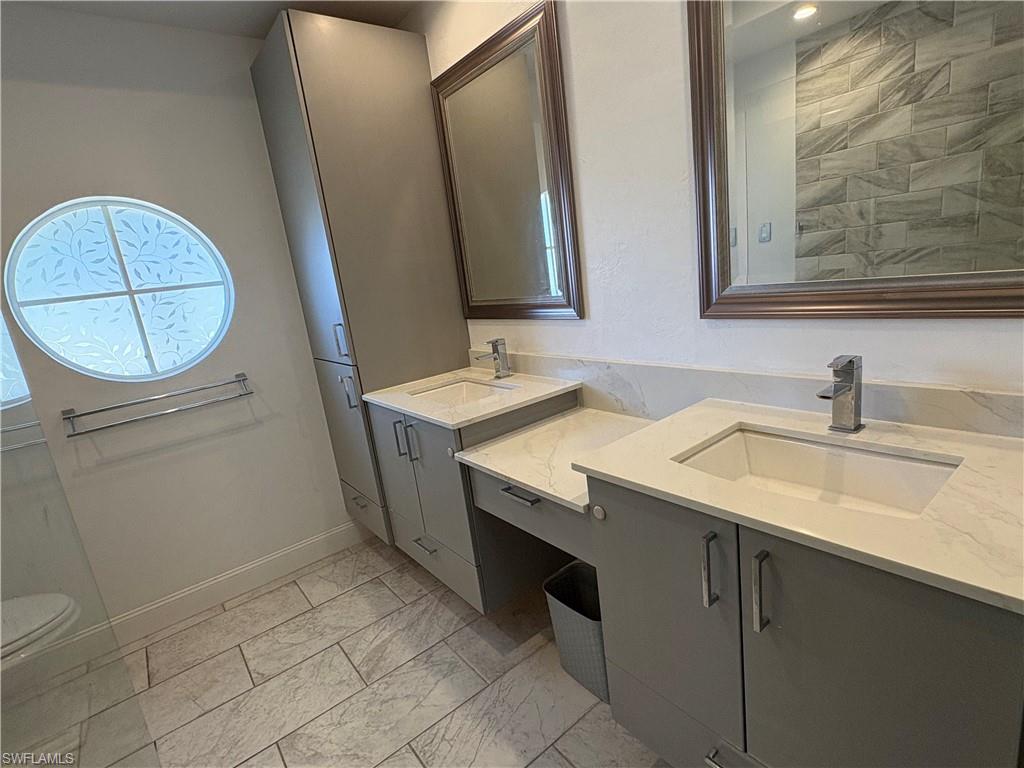 804 Bluebird Street Naples, FL 34104 - Photo 26 of 42 Full bathroom with two vanities and light marble finish floors
