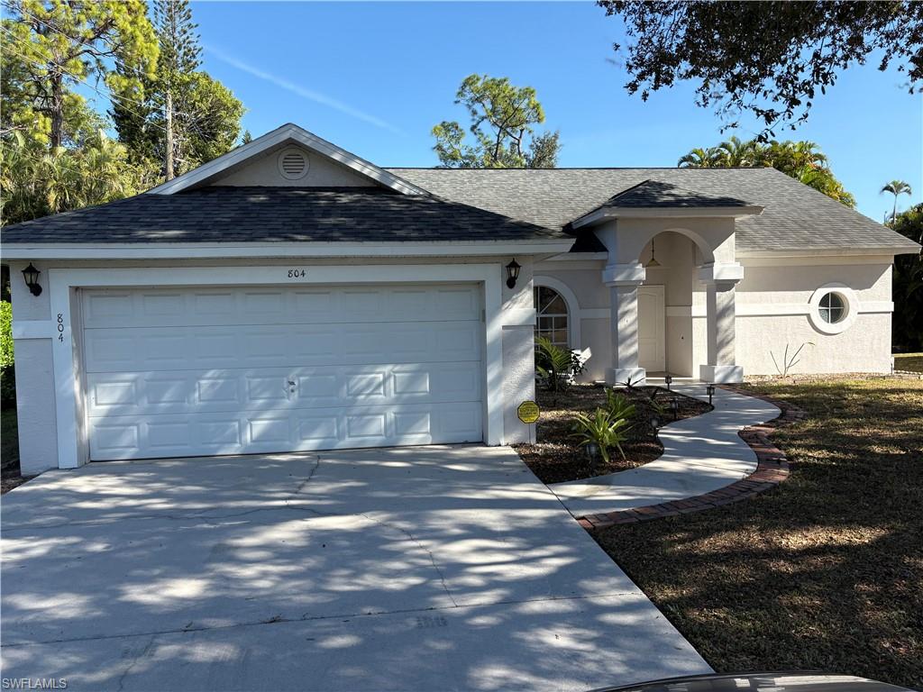 804 Bluebird Street Naples, FL 34104 - Photo 26 of 42 Ranch-style house with roof with shingles, driveway, and a garage