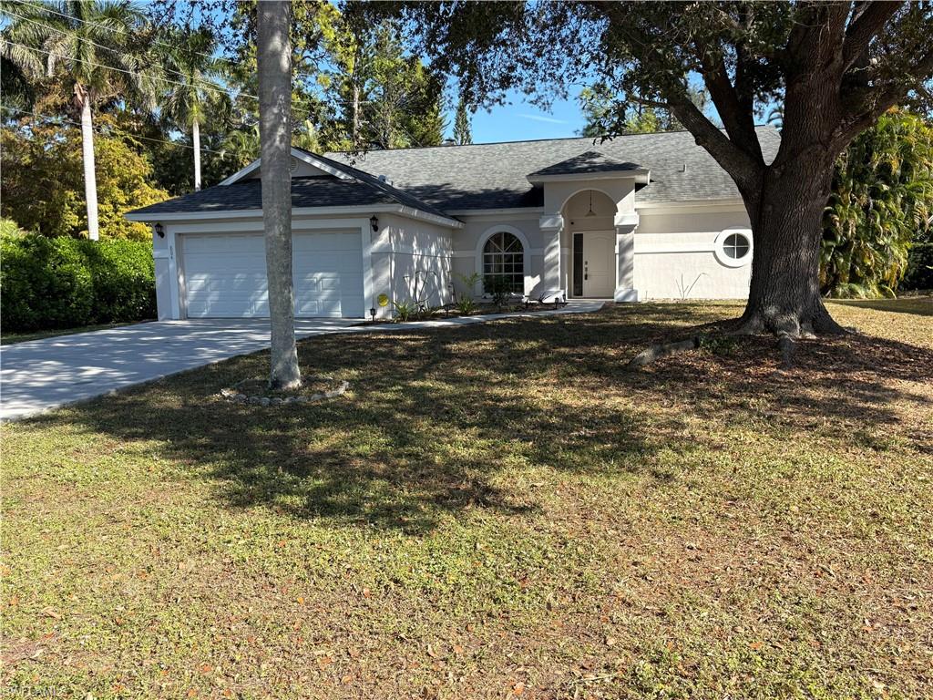 804 Bluebird Street Naples, FL 34104 - Photo 28 of 42 Ranch-style house featuring concrete driveway, a front yard, a shingled roof, and an attached garage