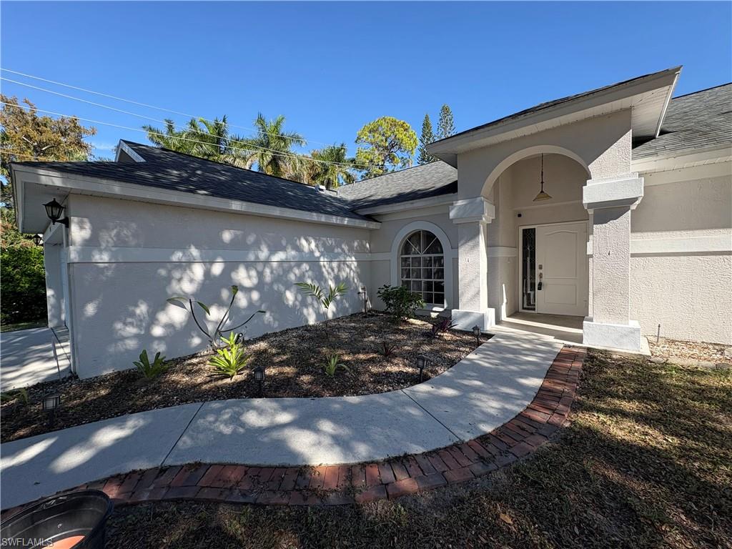 804 Bluebird Street Naples, FL 34104 - Photo 29 of 42 Entrance to property with stucco siding and a shingled roof