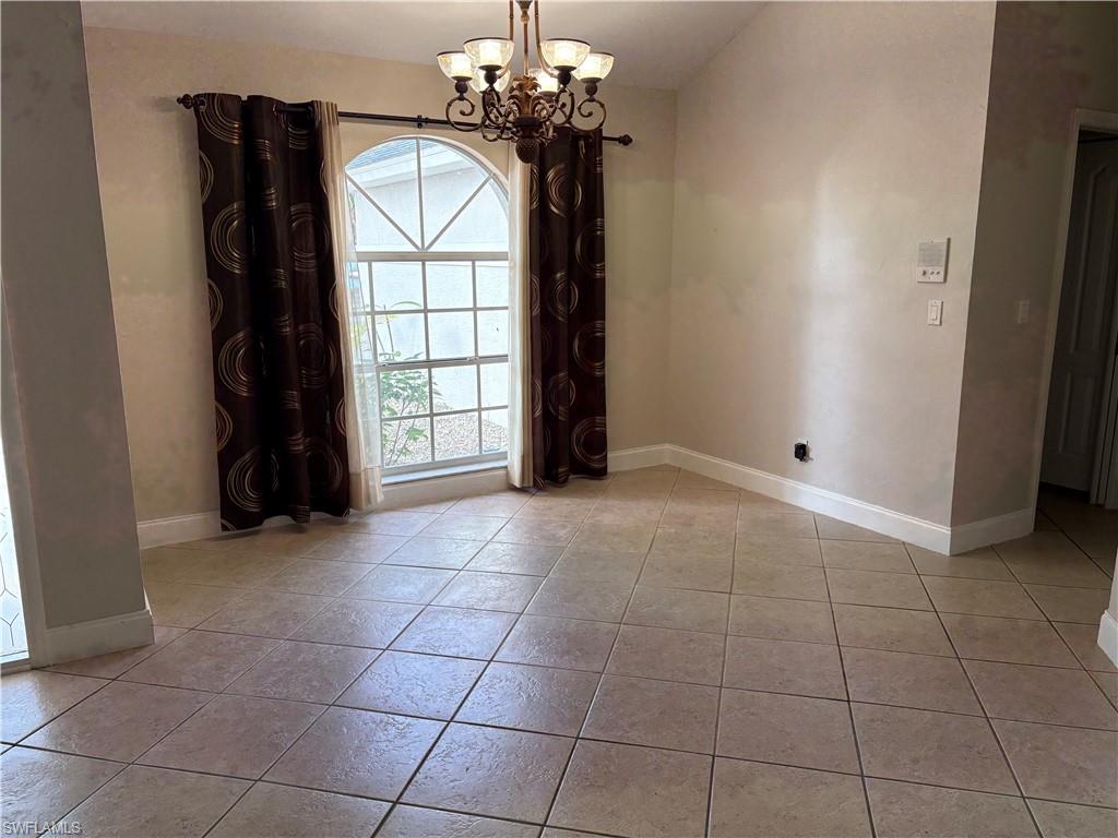 804 Bluebird Street Naples, FL 34104 - Photo 33 of 42 Unfurnished dining area featuring a chandelier and light tile patterned flooring