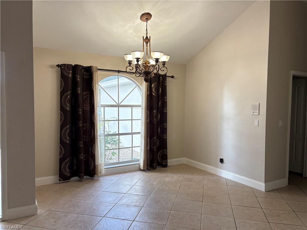 804 Bluebird Street Naples, FL 34104 - Photo 34 of 42 Empty room featuring a chandelier and light tile patterned floors