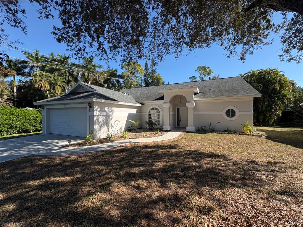 804 Bluebird Street Naples, FL 34104 - Photo 41 of 42 Single story home featuring concrete driveway, a front yard, an attached garage, and stucco siding